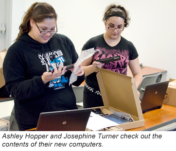 Ashley Hopper and Josephine Turner check out the contents of their new computer.